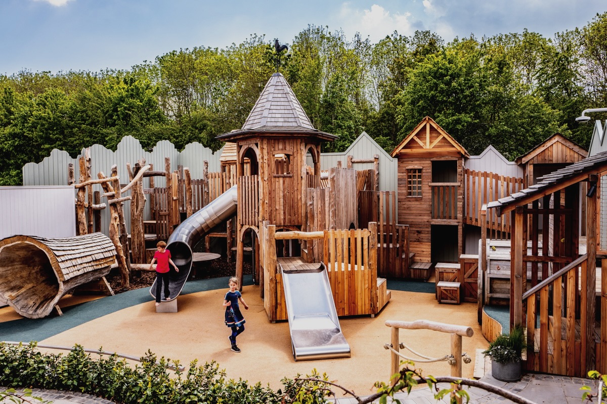 Colour photo of wooden adventure playground at Bicester Village, with towers, slides and walkways