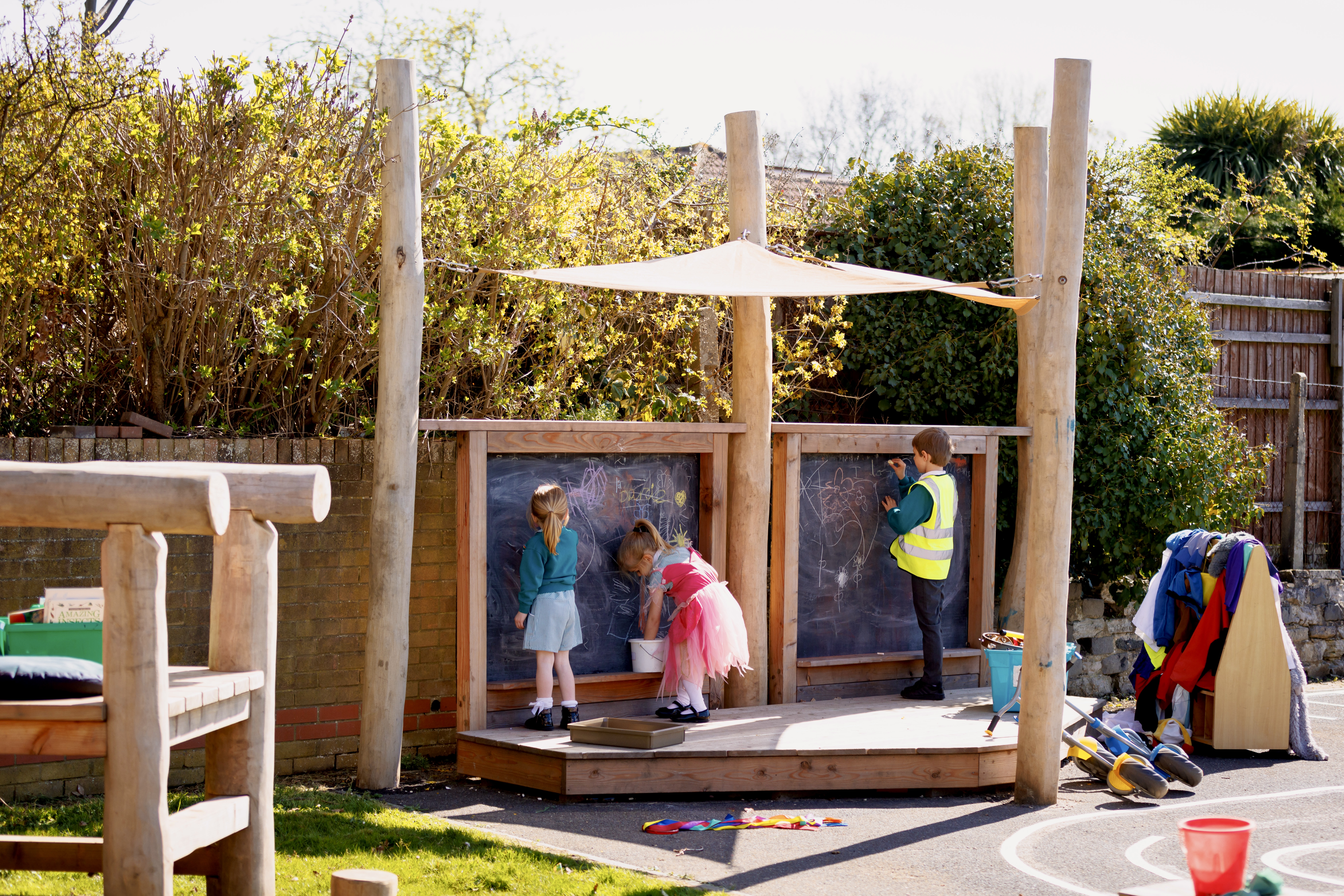 Colour photo of children playing on performance stage in Stanley Green school playground