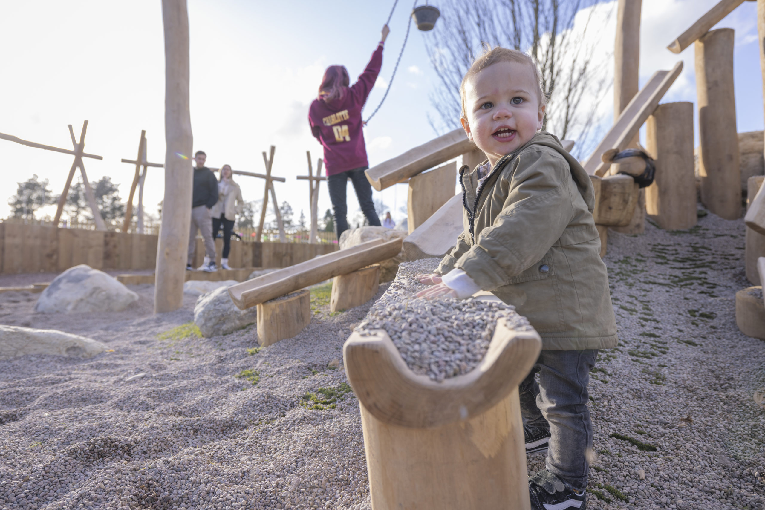 A child plays with gravel at a gravel pit playground.